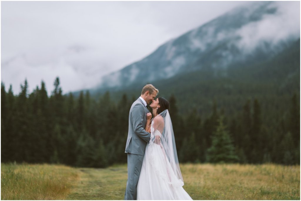 canmore alberta wedding bride and groom by river raining corry lake park