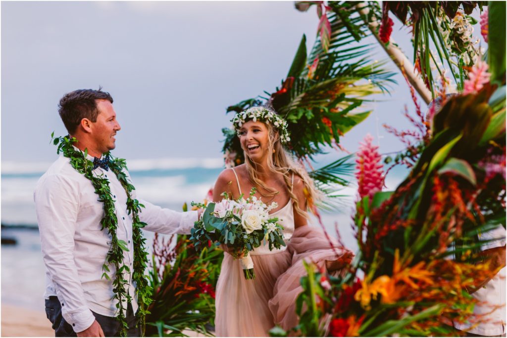 bride crying at beach wedding on kauai hawaii flower arch 